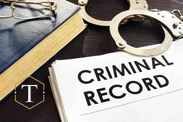 a criminal record next to handcuffs and a book of law