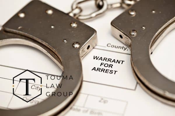 an arrest warrant with handcuffs on top of it