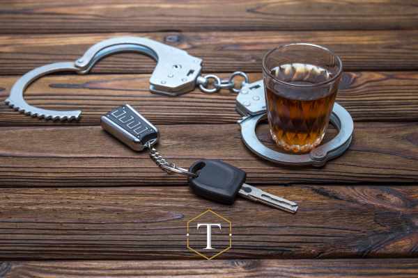 liquor, car keys, and handcuffs on a table